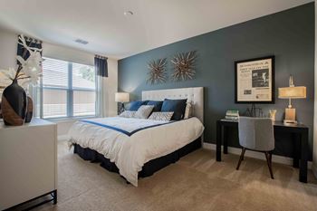 a bedroom with a bed and a desk with a chair